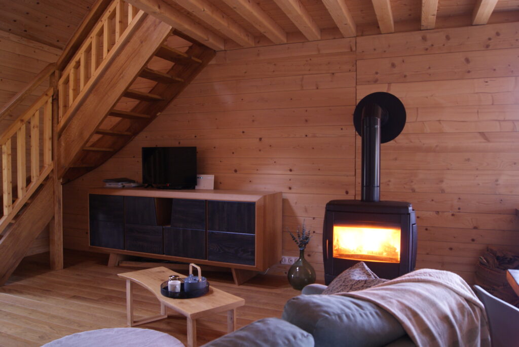 Grand canapé XXL devant le poêle à bois allumé du Chalet à Comté